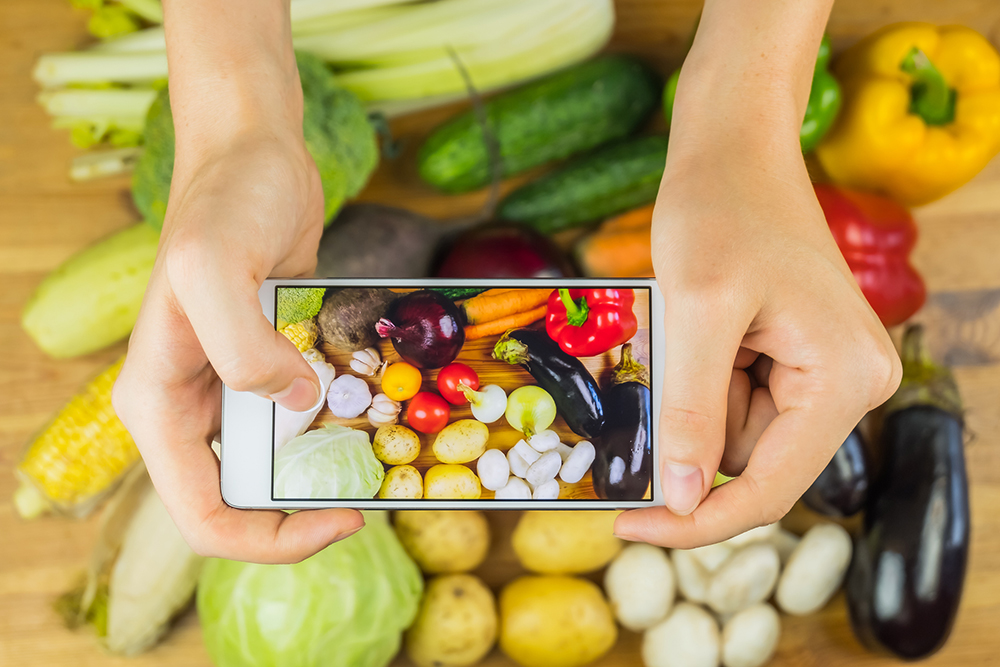 Taking photo of fresh organic vegetables on rustic wood table, top view